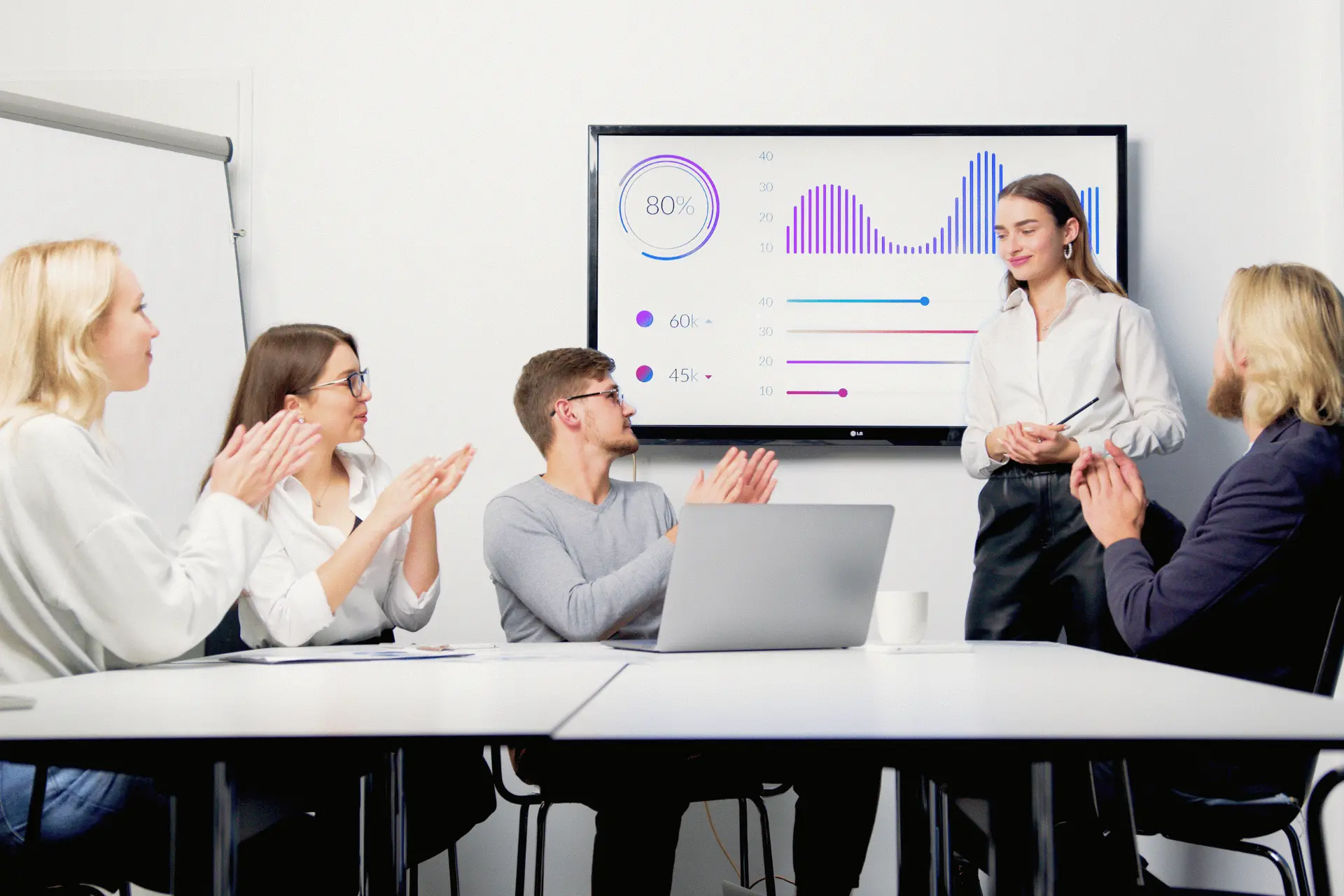 Team members reviewing communication analytics on a shared screen in an office.